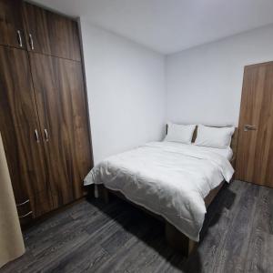 a bedroom with a white bed and wooden cabinets at Viilor Panoramic in Baia Mare