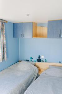 two beds in a room with blue walls at Louisiana in Anloo