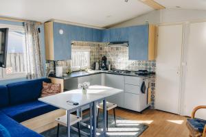 a kitchen with blue cabinets and a white table at Louisiana in Anloo