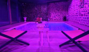 a room with a tub with a doll sitting on a stool at Jacuzzi XXL avec La Rouyonnaise in Tinténiac