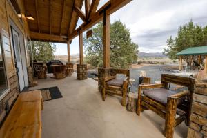 a porch with chairs and a view of a river at Anasazi Cliffs Lodging in Apple Valley