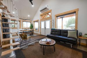 a living room with a black leather couch and a table at Anasazi Cliffs Lodging in Apple Valley