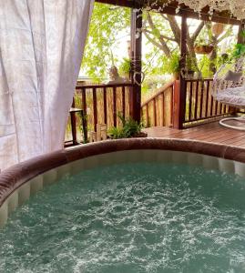 a hot tub on the deck of a house at Boho B&B in Amnon