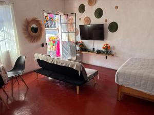 a living room with a bed and a piano in it at Casa Roma in Taxco de Alarcón