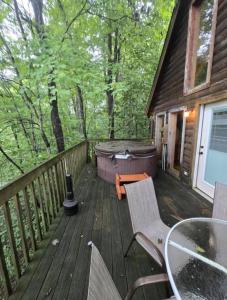 a wooden deck with a table and chairs on it at Mountain Memories - RRG in Rogers
