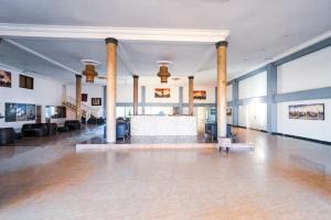 a large lobby with columns and a table in the middle at Balafon Beach Resort in Kololi
