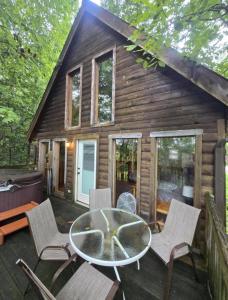 a cabin with a table and chairs on a deck at Mountain Memories - RRG in Rogers