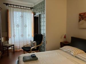 a bedroom with a bed and a chair and a window at La Casa Di Cosimo Guest House in San Piero a Sieve
