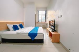 a bedroom with a bed and a flat screen tv at Staigo at SG Premium in Medan