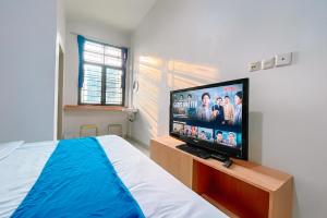 a bedroom with a flat screen tv on a wooden stand at Staigo at SG Premium in Medan