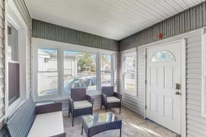 a porch with chairs and a table and a door at Group-Friendly Michigan City Home Near Beach! in Michigan City