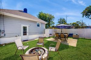a backyard with a table and chairs and an umbrella at Group-Friendly Michigan City Home Near Beach! in Michigan City