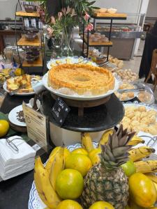 a table with a pie and a display of fruit at Tamareiras Prime Hotel in Uberaba +35 photos