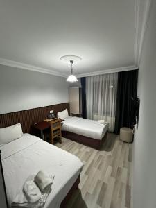 a hotel room with two beds and a desk at Balkan Palace Edirne in Edirne +32 photos