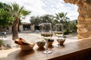 two glasses of white wine and bread on a table at Villa Roba degli Ulivi in Agrigento