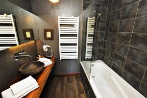 a bathroom with a tub and a sink and a bath tub at Logis Hôtel - Auberge les Clarines in Le Châtelard +15 photos