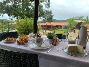 a table with a white table cloth with bread and wine glasses at Pousada Dona Bili in Pirenópolis