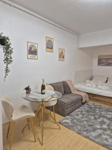 a living room with a couch and a table and a bed at ZenCozy Studio - Free Underground Parking in Bucharest