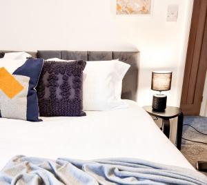 a bedroom with a white bed with pillows at Urban Escape Stylish 3BR in Swansea in Swansea +9 photos