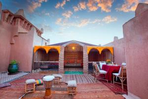 un patio avec une table et des chaises dans un bâtiment dans l'établissement Riad Ouarzazate, à Ouarzazate