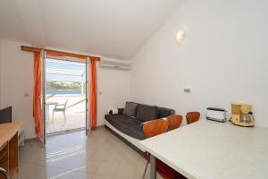 a living room with a couch and a table at Apartmani Kaštel in Stara Novalja