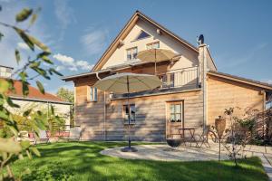 a house with an umbrella in the yard at Haus Herzbluat in Peiting