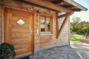a wooden shed with a door and a window at Haus Herzbluat in Peiting +37 photos