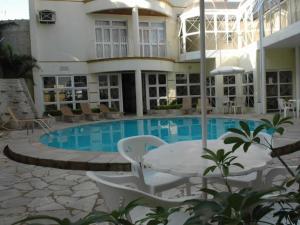 a hotel with a swimming pool in front of a building at Tamareiras Prime Hotel in Uberaba