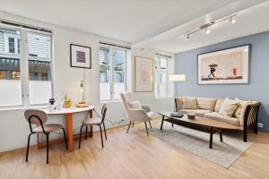 a living room with a couch and a table and chairs at Harmony apartments - Stavanger sentrum in Stavanger