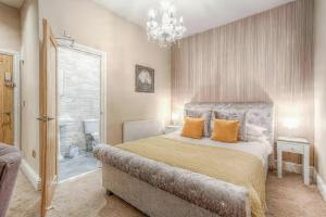 a bedroom with a large bed and a chandelier at The George Wright Boutique Hotel, Bar & Restaurant in Rotherham