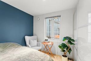 a bedroom with a bed and a chair and a window at Harmony apartments - Stavanger sentrum in Stavanger
