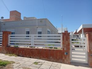 a white fence in front of a house at Ein gutes Haus in Mina Clavero