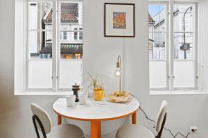 a table and chairs in a room with windows at Harmony apartments - Stavanger sentrum in Stavanger +32 photos