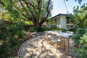 a patio with a table and chairs in front of a house at Sundance steps to Half Moon Bay in Black Rock North