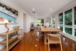 a dining room with a wooden table and chairs at Sundance steps to Half Moon Bay in Black Rock North