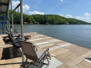 a couple of chairs sitting on a dock next to the water at Mimosa Mornings Home for 12 in Rocky Mount