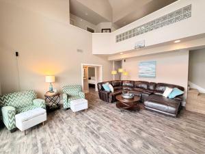 a living room with a leather couch and chairs at Mimosa Mornings Home for 12 in Rocky Mount