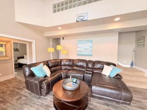 a living room with a leather couch and a table at Mimosa Mornings Home for 12 in Rocky Mount