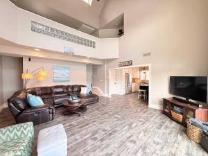 a living room with leather furniture and a flat screen tv at Mimosa Mornings Home for 12 in Rocky Mount +42 photos