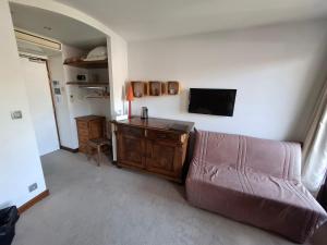 a living room with a couch and a flat screen tv at Logis Hôtel - Auberge les Clarines in Le Châtelard