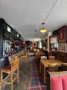 a restaurant with wooden tables and chairs and a bar at The Clothiers Arms in Stroud
