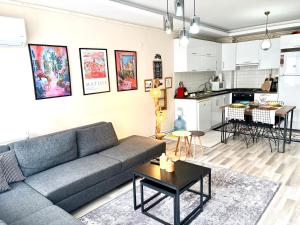 a living room with a couch and a kitchen at Theos Holiday Apartments Room 23 Family Suit Accommodation For Families Only in Kuşadası
