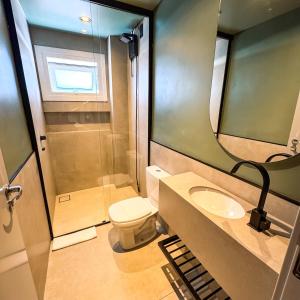 a bathroom with a toilet and a sink and a mirror at Hotel Zata e Flats in Criciúma