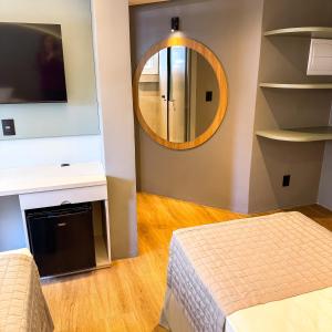 a bedroom with a bed and a mirror at Hotel Zata e Flats in Criciúma +107 photos
