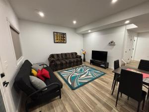 a living room with a couch and a table at Fowler Road Cozy Lower Suite in Airdrie +5 photos