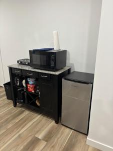 a kitchen with a microwave and a small refrigerator at Fowler Road Cozy Lower Suite in Airdrie