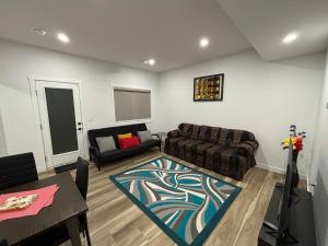 a living room with a couch and a table at Fowler Road Cozy Lower Suite in Airdrie