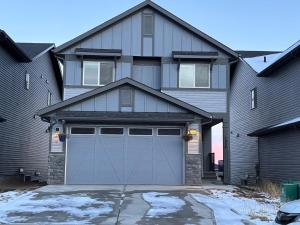 a large house with a garage door in front of it at Fowler Road Cozy Lower Suite in Airdrie