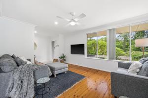 a living room with a couch and a tv at Salt & Sand - Flynn's Beach in Port Macquarie