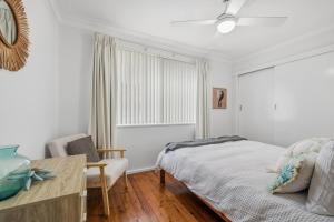 a bedroom with a bed and a table and a window at Salt & Sand - Flynn's Beach in Port Macquarie